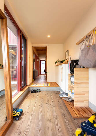 無垢板張りの土間が温かみを感じさせる玄関 無垢の土間でも 手入れは一般的な土間とほとんど変わりありません とご主人 窓からウッドデッキと庭