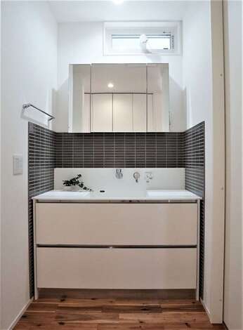 タイルがモダンな印象を与えるサンワカンパニーの洗面台 洗面室と脱衣室を分けたことで 誰かが入浴中でも歯磨きや洗面ができる イエタテ