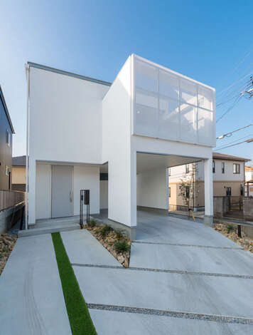 白いキューブ型のスタイリッシュな外観 ガレージ上の屋上テラスを囲ったパンチングパネルが意匠性を高めるとともに 周囲の視線を遮りつつも屋内から