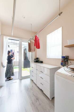 洗濯機と収納を備えるユーティリティを キッチン裏に配置 平日夜の室内干しスペースとしても十分な広さを確保 休日は外に干すため ウッドデッキを