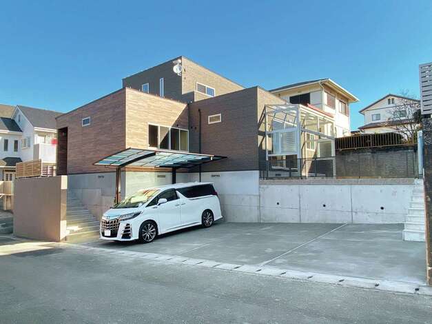 旧宅は建物の下の擁壁内に2台分の駐車場があり 行き来が不便だったため 駐車場を平置きで4台分確保 玄関側と庭側に階段を設け 行き来が格段に便