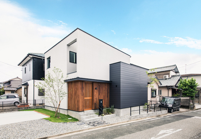 敷地の北側に駐車場を確保するため 建物は南側いっぱいまで詰めて建ててある 壁で囲われた玄関ポーチの上は吹抜けにしてあり サイドも大きく開口し