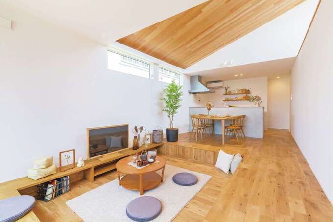 Ldkは 仕切りのない間取りと勾配天井によって実寸以上に開放的な空間を実現 床を掘り下げたことで 座った際に見えるのは空だけ カーテンが要ら