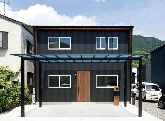 屋根も勾配も付けない真四角で 窓の配置は左右対称にと こだわりを表現した外観 黒のガルバリウム鋼板は奥さまの選択 軒天井には天然木をあしらっ
