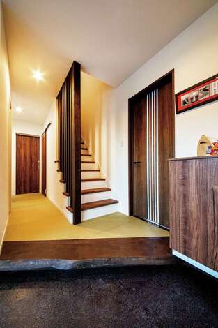 重々しい 和 の雰囲気にならないよう マリンブルーのガルバリウム鋼板でモダンなテイストをプラスした外観 玄関に続く石段はご主人のお気に入りで