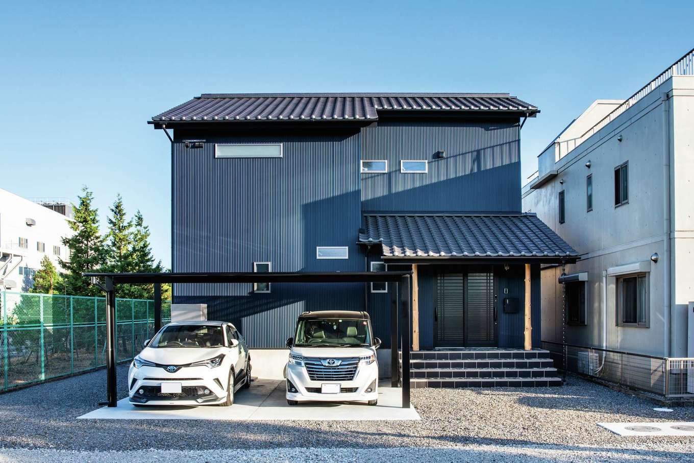 重々しい 和 の雰囲気にならないよう マリンブルーのガルバリウム鋼板でモダンなテイストをプラスした外観 玄関に続く石段はご主人のお気に入りで