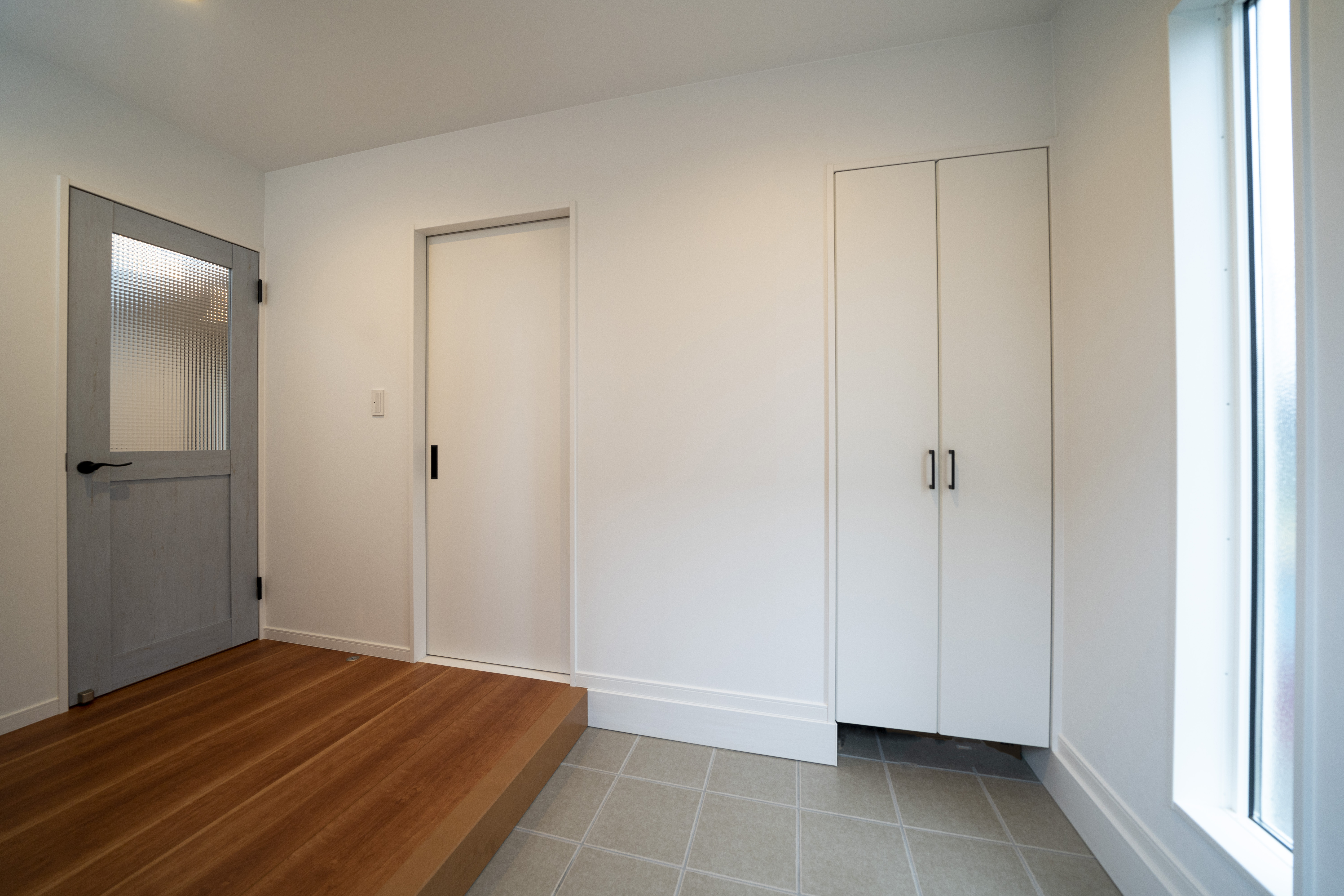 玄関は大型収納付きで 家族の靴や季節用品をたっぷりしまえて便利 シンプルな空間のアクセントに水色のリビングドアを採用 イエタテ