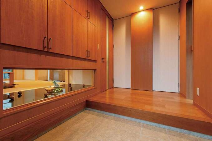 できるだけ玄関を広くしたいというご主人の要望を受け シューズクロークを壁面収納スタイルに 和室が見える地窓を設けたことで目線が抜け より開放