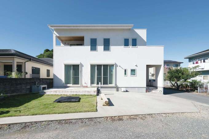 白い塗り壁の外観が青空に美しく映える メンテナンスを考慮し デッキはタイル張りに イエタテ