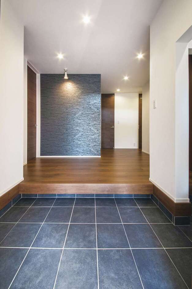 大勢の来客に対応できるように 土間とホールにゆとりを持たせた玄関 正面には石目調のアクセントクロスを用い上質感を演出 イエタテ