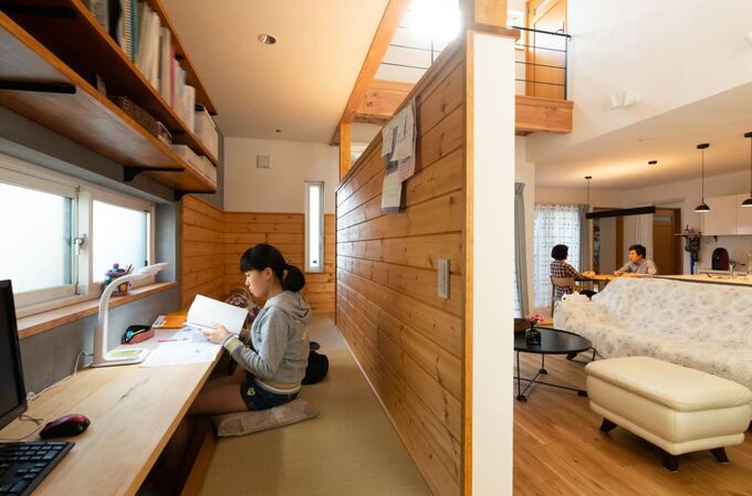 リビングの延長線上に設けた小上がりの書斎 夫婦共有の空間になるはずだったが すっかり長女に占領されている様子 リビングにいる両親の気配を感じ