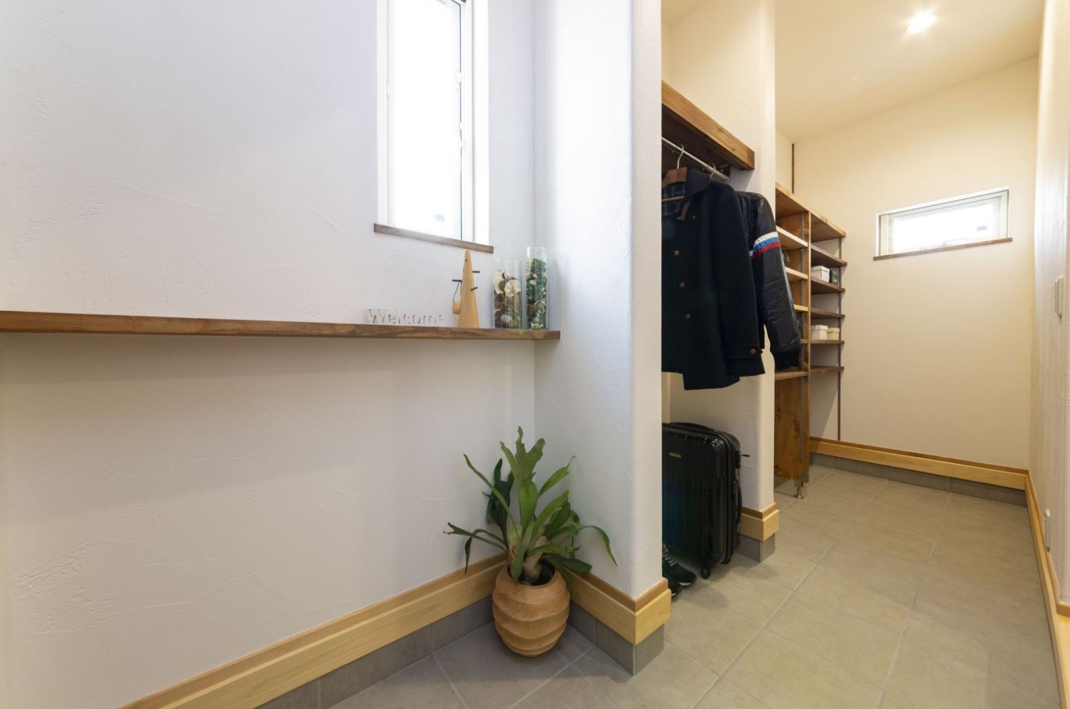 収納がたっぷり欲しいという奥さまの要望に応えて 土間仕上げの玄関に大容量のクローゼットを造作 外着やスーツケースもここに収納することで 居室