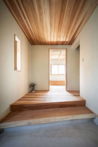 扉を開けて一歩中へ入ると 一枚板のクルミの木でつくられた玄関の式台が目を惹く イエタテ