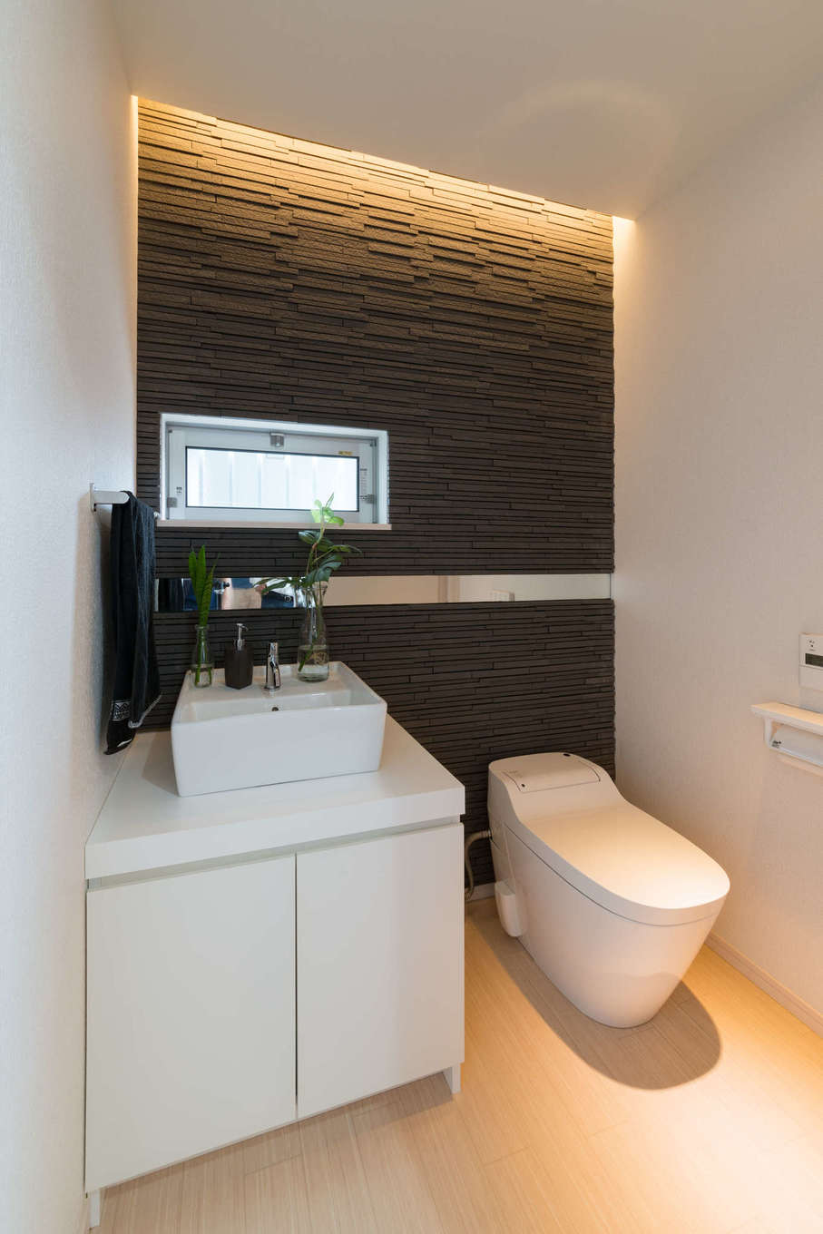 トイレも広さにゆとりがあり 石張りのアクセントウォールと間接照明で上質な空間を演出 石張りの壁には玄関と同様に鏡をボーダーのように貼ってあり
