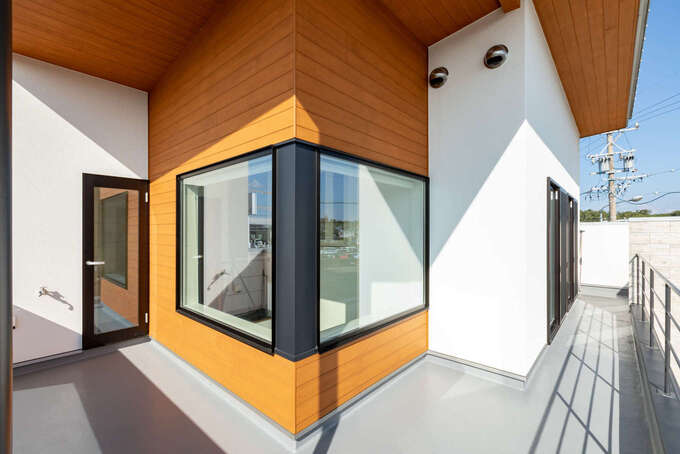 2階の外壁にl字型に設けた窓は 玄関の吹抜けに面している スギ板張りの軒天と外壁がアクセントとなって外観の意匠性を高めている イエタテ