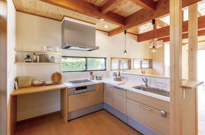 キッチンはl字型にして作業スペースを広く確保 電磁調理器の隣には造作のゴミ箱収納を設置 上部のカウンターは調理スペースや家電置き場など多目的