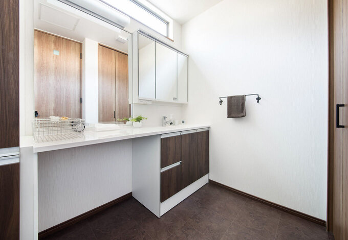 朝の忙しい時間帯は 二人の支度が重なりがちに そんな悩みは 横並びで使える洗面所で解消 洗濯機コーナーには扉を設置し 生活感を感じさせない工