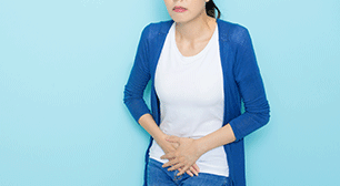 お腹に手を当てる女性,産後,生理,