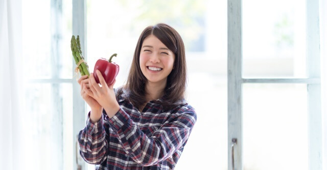 野菜を持って喜ぶ女性,