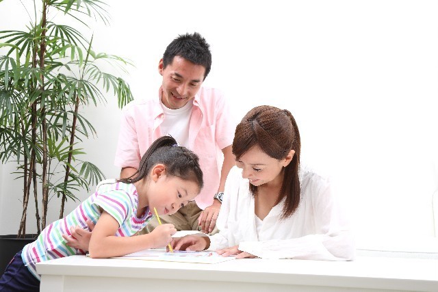 子どもの勉強を見守る両親,学資保険,