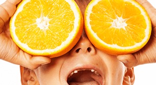 オレンジを目に当てている子,乳歯,永久歯,欠けた