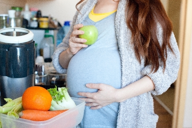お腹に手を当てる妊婦,妊娠,32週,胎児