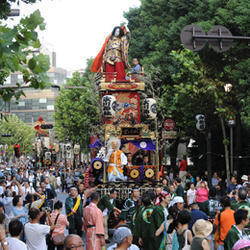 東京のお祭りと言えば御神輿を担ぐ人々と観客の画像
