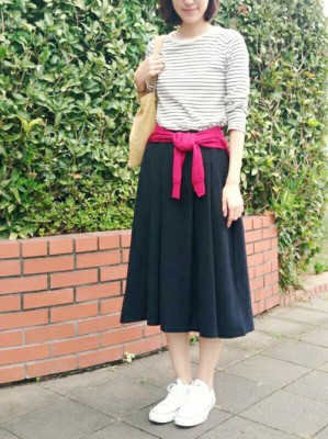腰に巻いたカーディガンがアクセントのミモレ丈スカートの画像