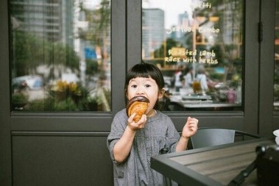 上野で買買ったお土産のドーナッツを食べる子どものイメージ画像
