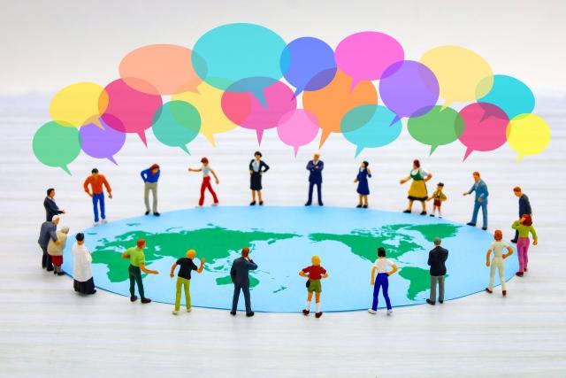 年齢・性別・国籍の異なる人々が輪になって笑顔で語り合う様子。多様性と対話の温かい雰囲気を表現