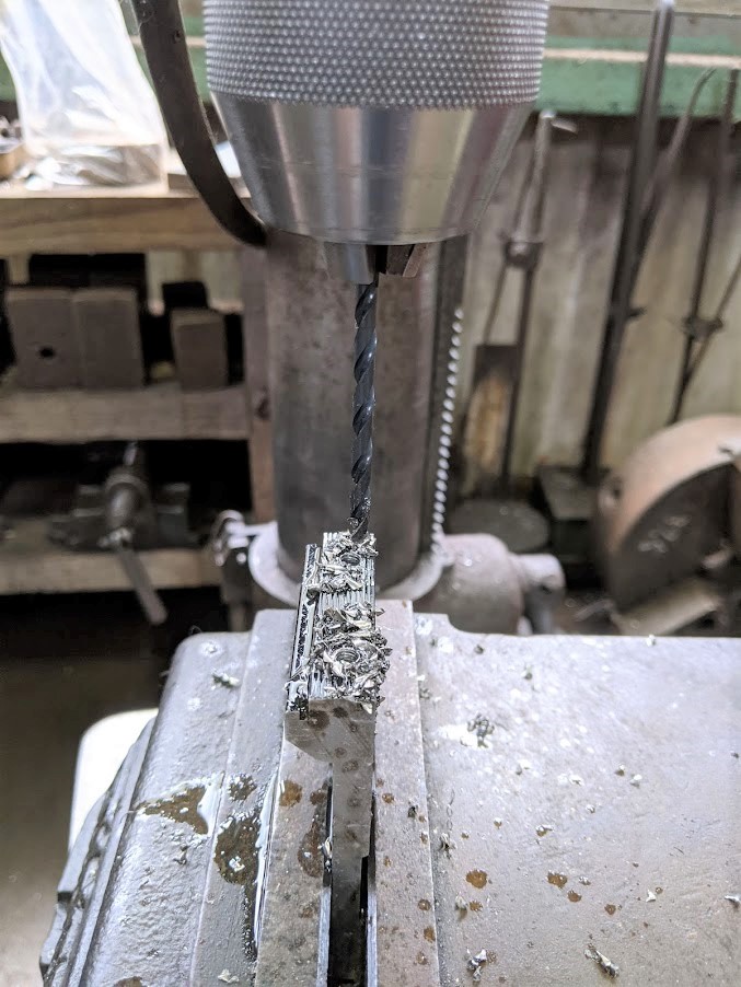 ボール盤にキリをセットして折れ込んだボルトの中心に穴あけ。