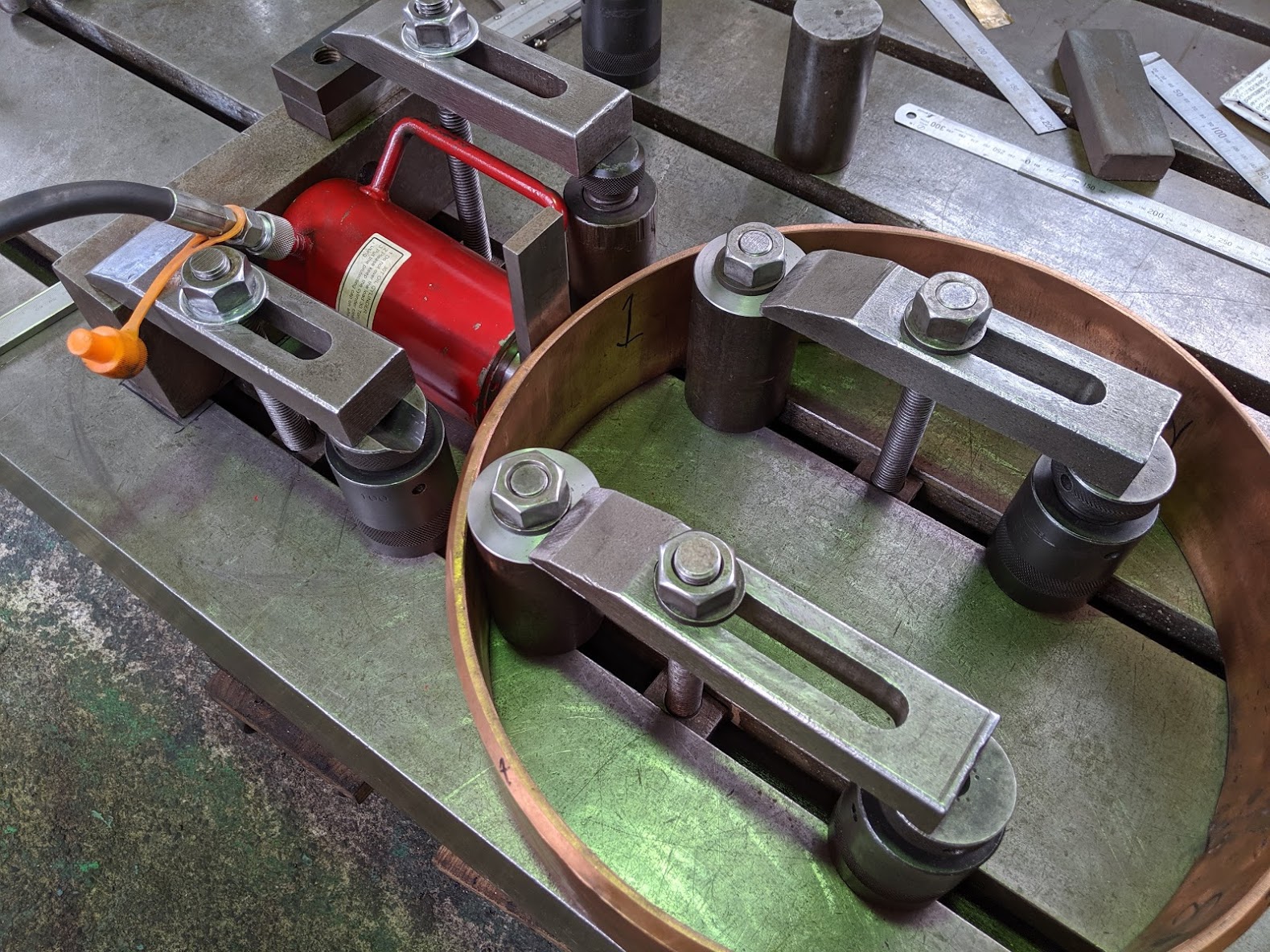 油圧ジャッキを上手く利用して銅電極の歪み取り装置を設置。