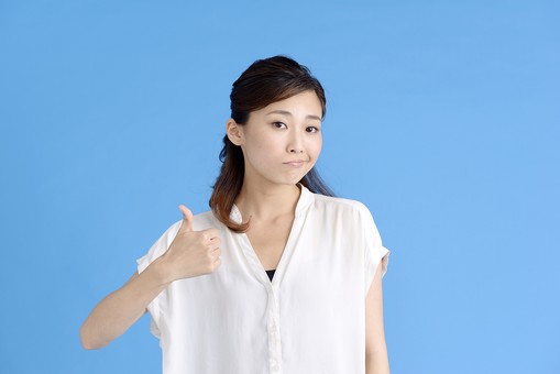 女性 ポーズ 人物 30代 日本人 黒髪 爽やか カジュアル 屋内 正面 上半身 ブルーバック 青背景 半そで 白 ウィンク 片目 瞑る 右手 サムズアップ やったね ヤッター ひねくれ やっかみ 口 曲げる 嫉妬 親指 立てる mdjf013