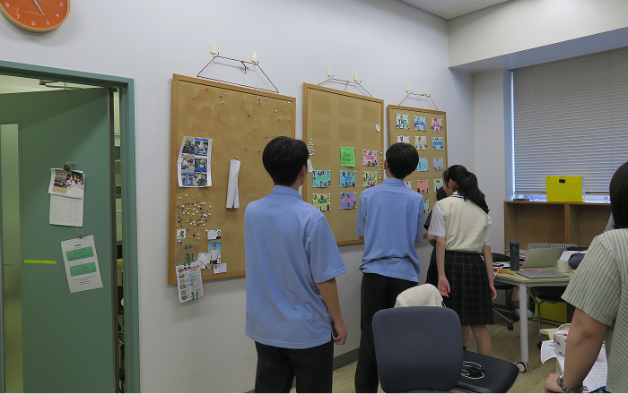 休憩ではゼミ内を探索。ゼミ生のプロフィールが貼られたボードを興味津々の様子で見る生徒たち