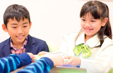 キッザニアの専用通貨「キッゾ」の受け渡しの様子