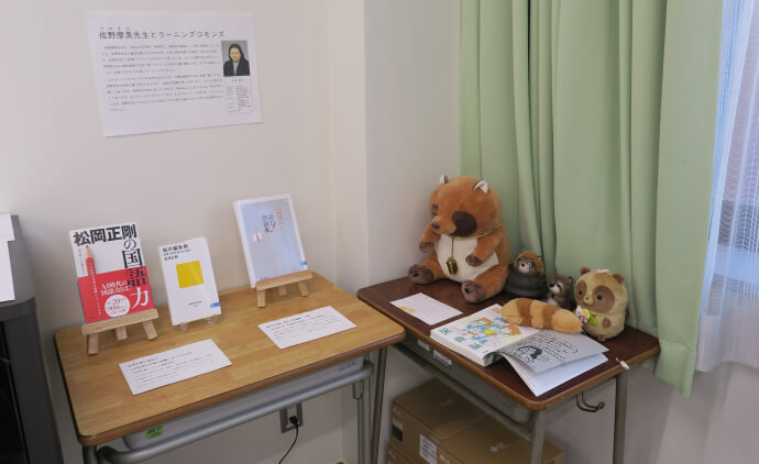 佐野先生が携わった本を紹介するコーナー。マスコットキャラのタヌキのぬいぐるみも！