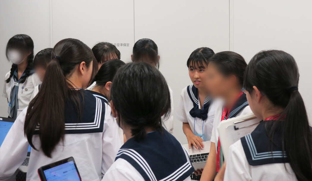 議場を回りながら積極的に各国大使の意見を聞くR.S.さん