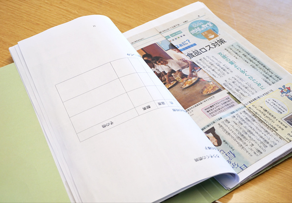 新聞の切り抜きが貼られた手作りの資料