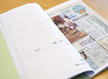 新聞の切り抜きが貼られた手作りの資料