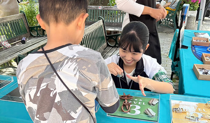 スイーツフェスタで知恵の輪を教えているS.Y.さん