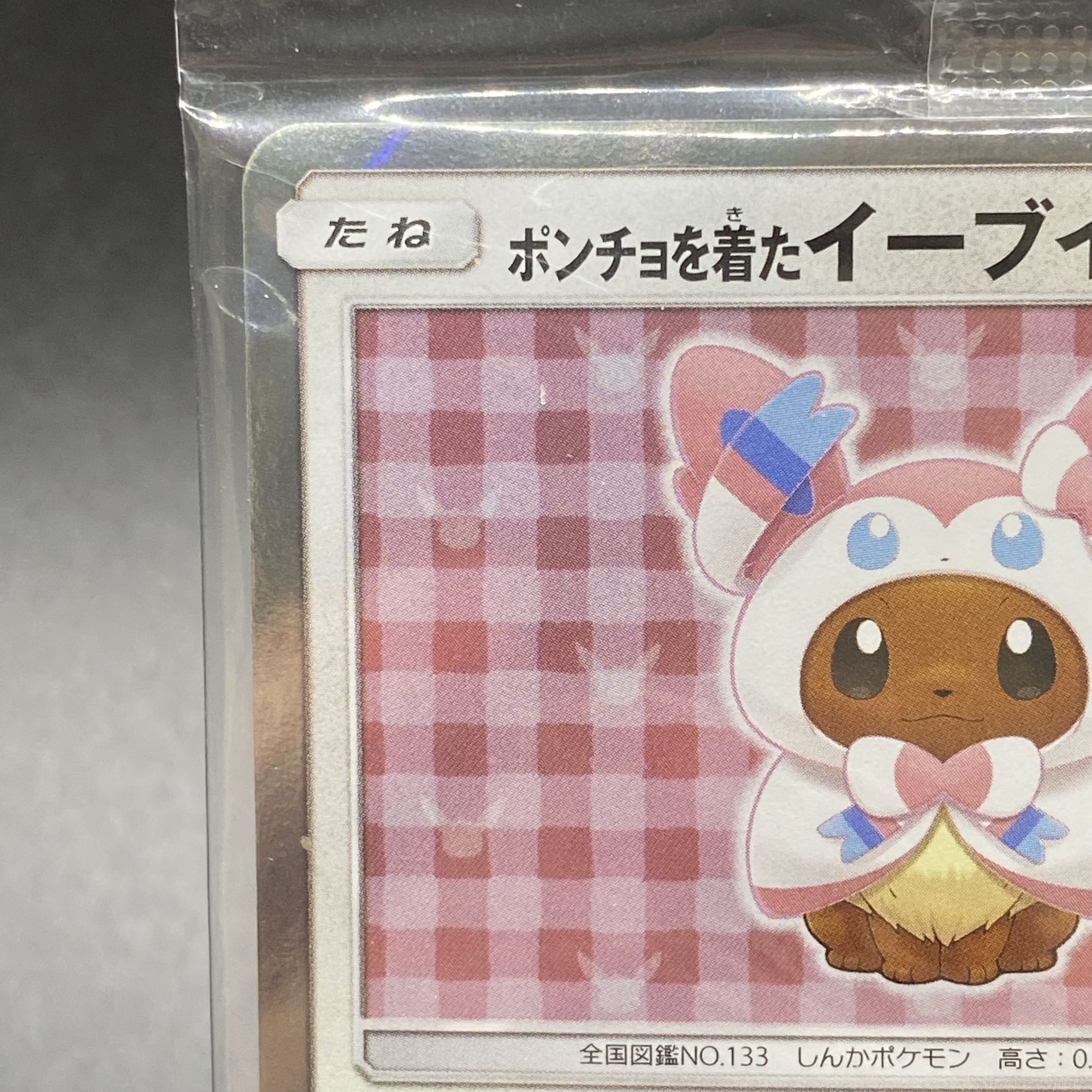 Eevee PROMO 144/SM-P in poncho, unopened pack