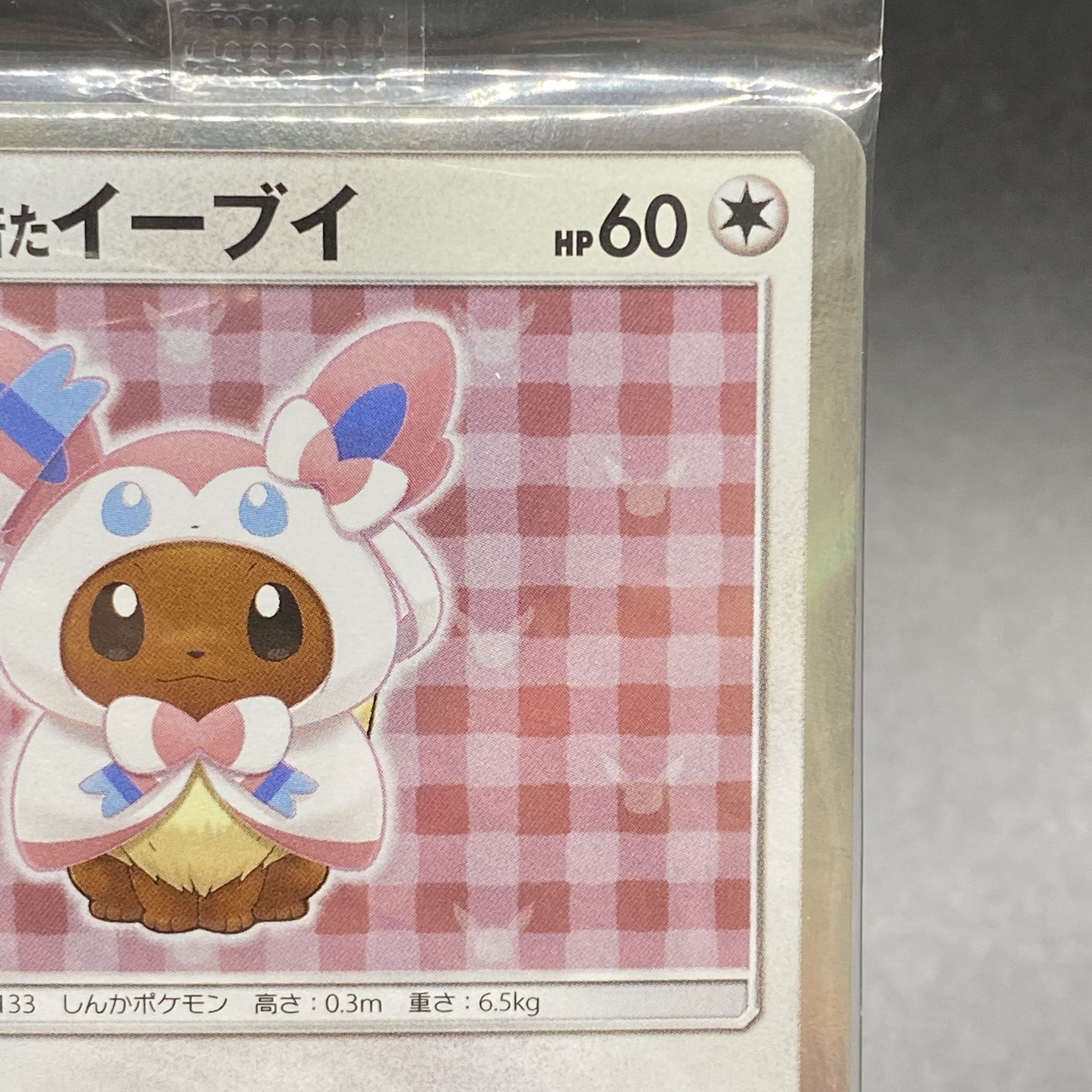 Eevee PROMO 144/SM-P in poncho, unopened pack