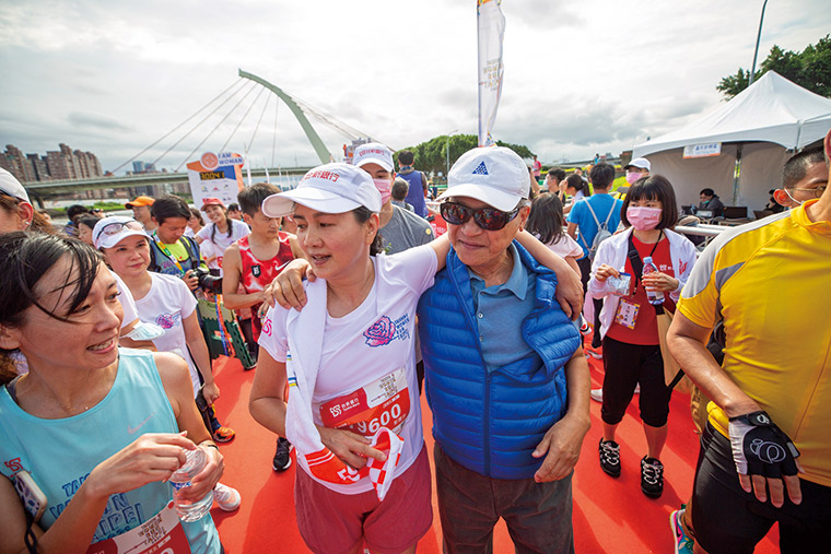 2021年，彭雪芬（左）參加台新女子路跑，領跑 1 21公里組，結束後由夫婿吳東亮（右）攙扶陪伴。