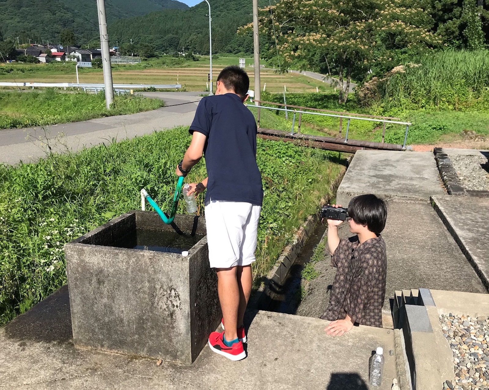 地域のPRのため、湧き水のCM撮影をするメンバー