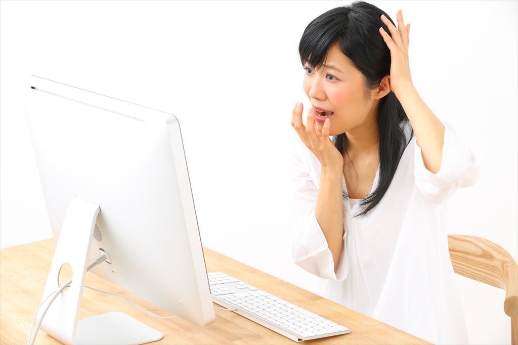 PCを前に困る女性