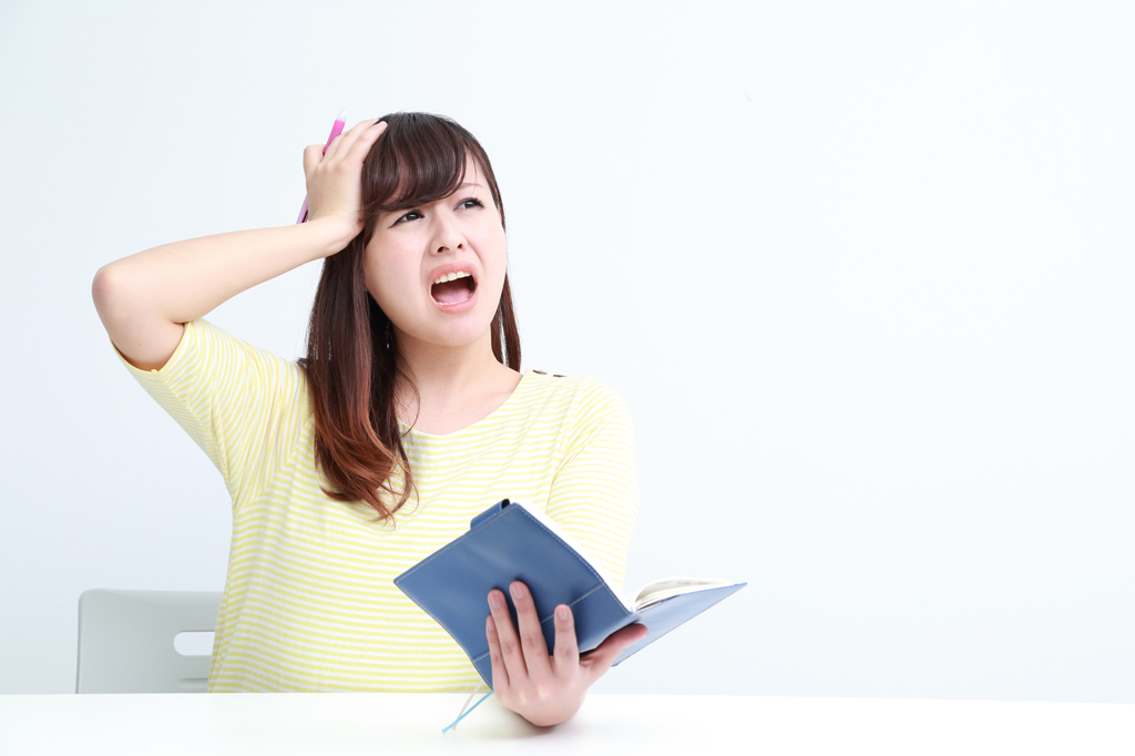 手帳を見て慌てる女性