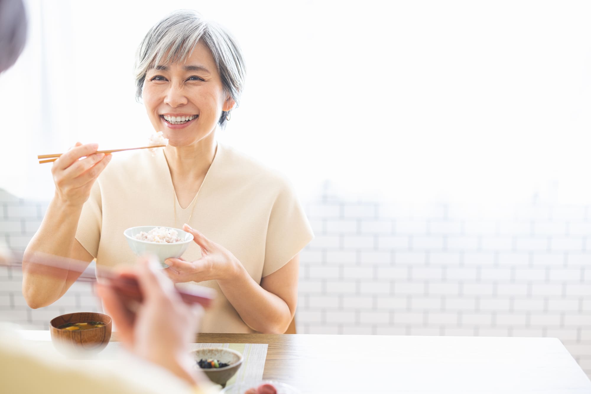 笑顔で食事をするシニア女性