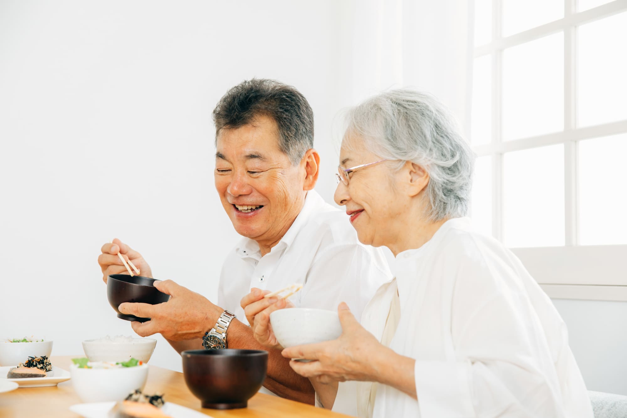笑顔で食事をする高齢の男女
