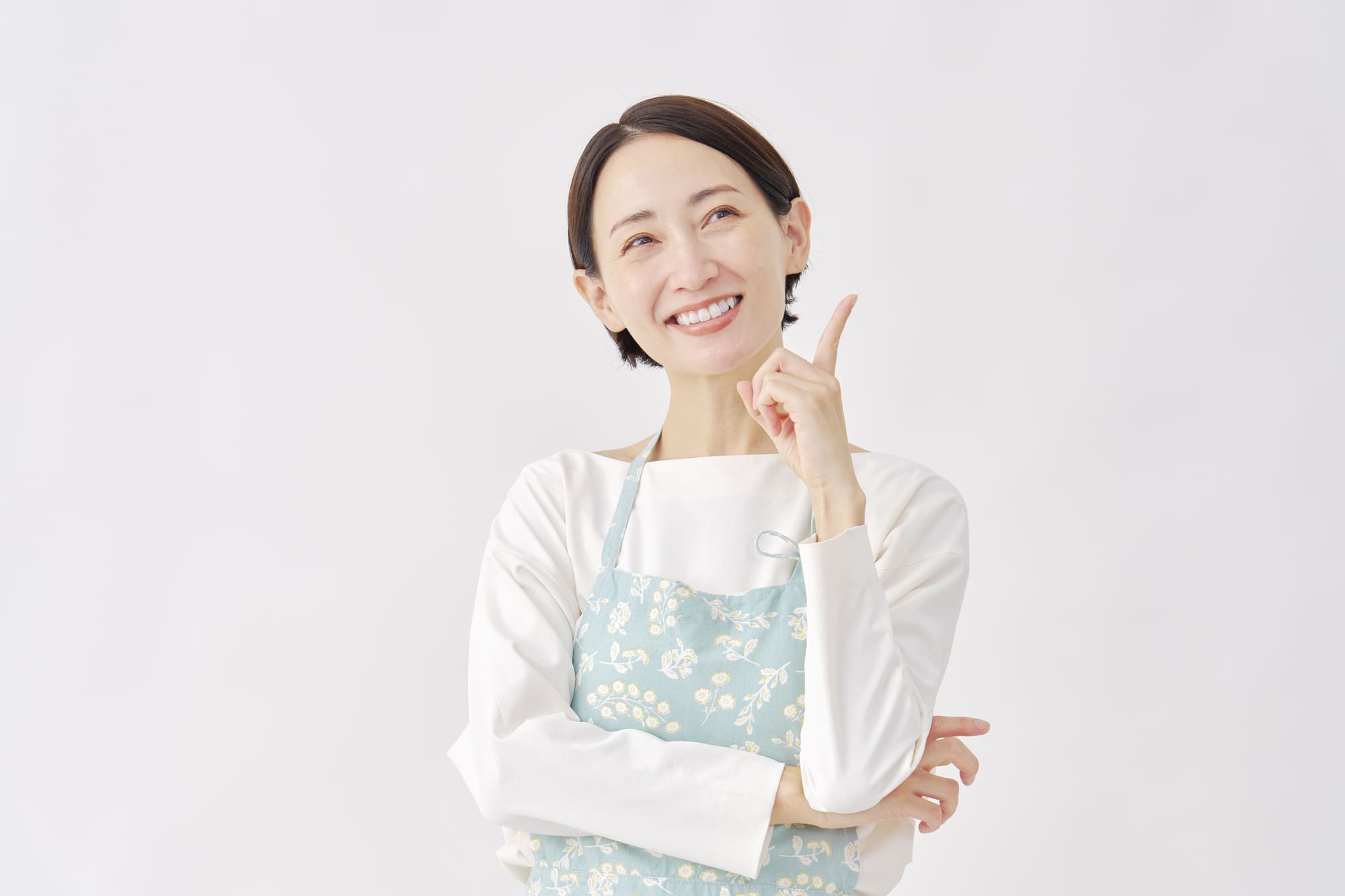 人さし指を上に向け、ひらめいた表情の女性
