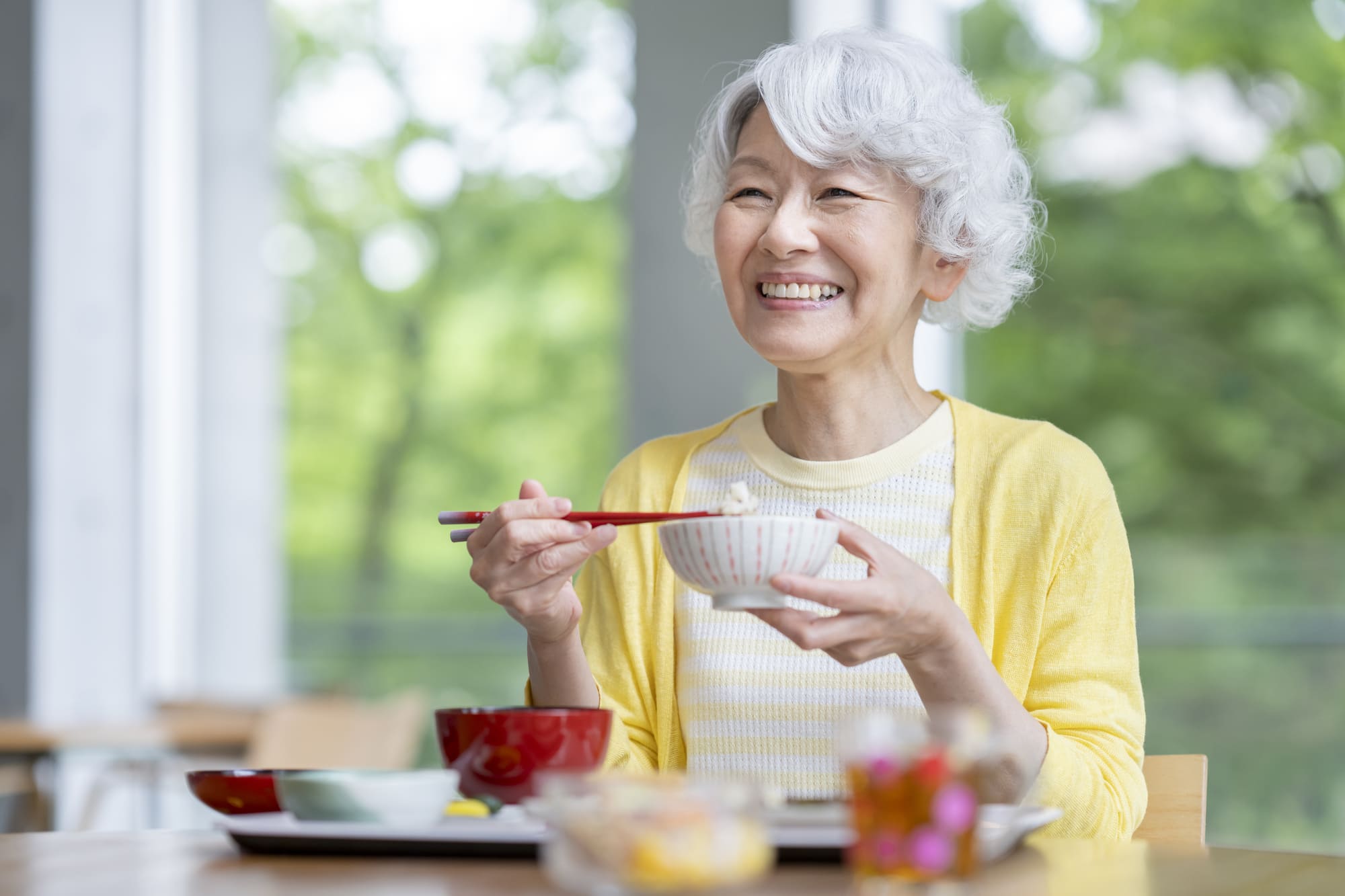 笑顔で食事を楽しむシニア女性